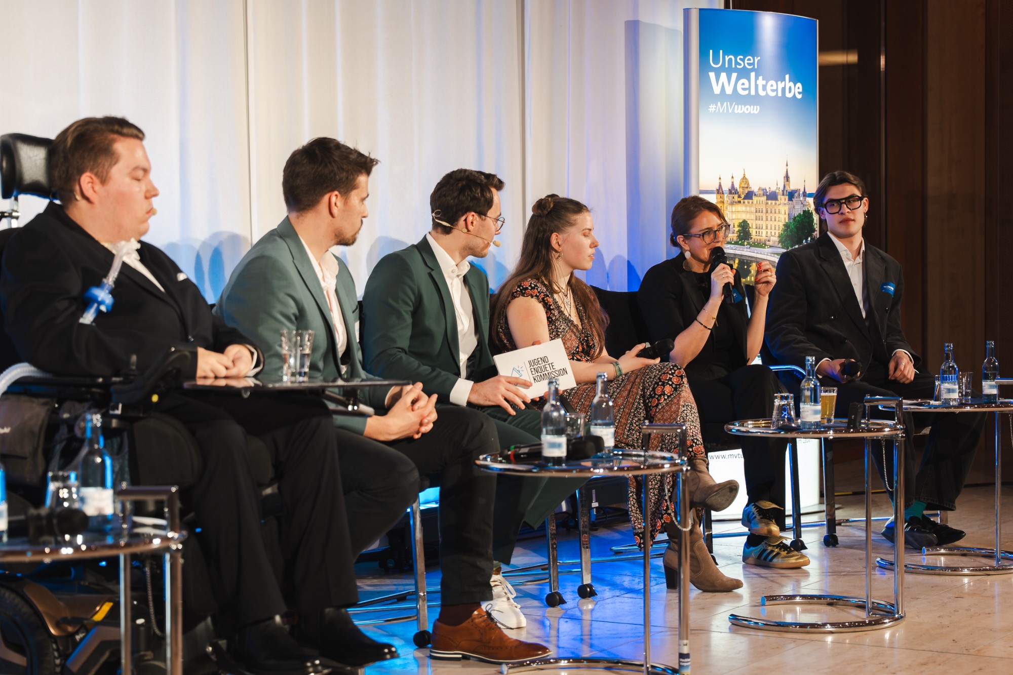 Edunovo bei der Übergabe des Policy Papers der Jugend-Enquete-Kommission 2025: Nils bringt unsere Perspektive auf Bildungsgerechtigkeit ein Paneldiskussion mit fünf Personen, die an einem Tisch sitzen und sich austauschen.