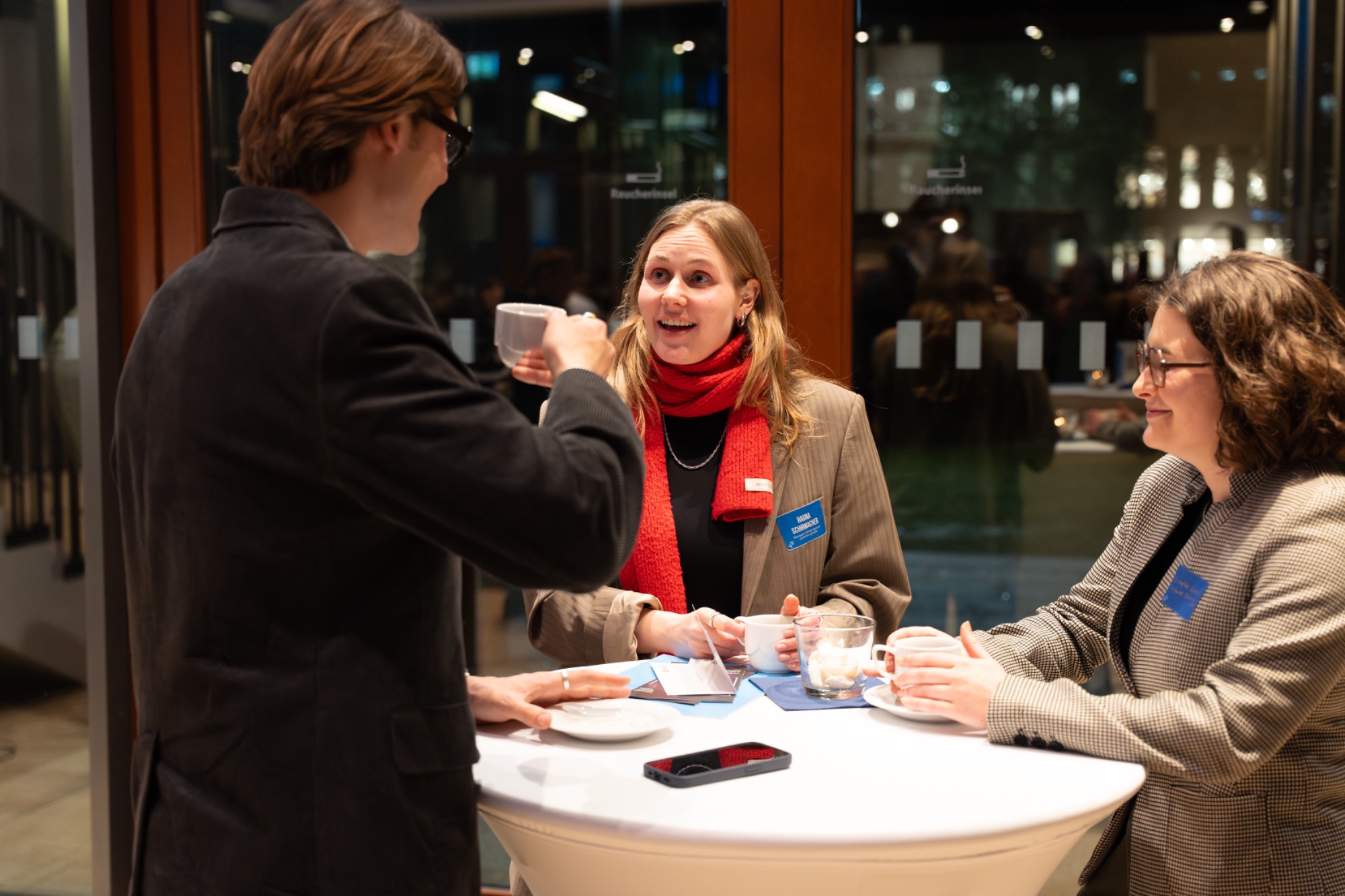 Edunovo im Austausch beim Bildungsevent der Jugend-Enquete-Kommission 2025 in Berlin Drei Personen stehen am Stehtisch, lächeln und halten Tassen in einer modernen Umgebung.
